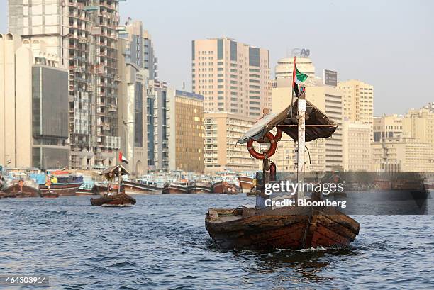 The national flag of the UAE flies from a water taxi, also known as an abra, on the waterway in Al Ghubaiba's creek district of Dubai, United Arab...