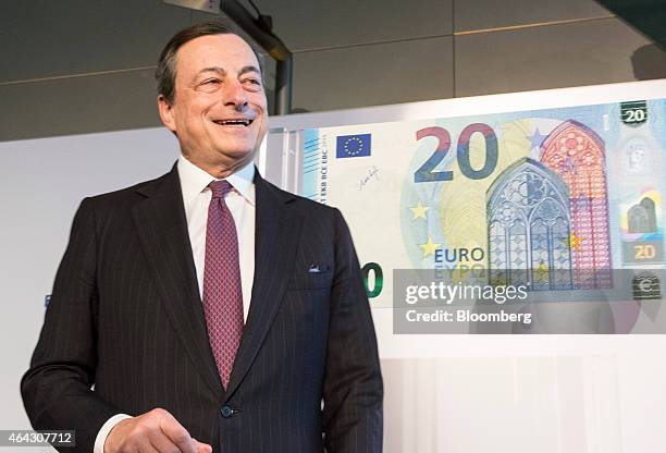 Mario Draghi, president of the European Central Bank , reacts as he unveils a new twenty euro banknote at the ECB headquarters in Frankfurt, Germany,...