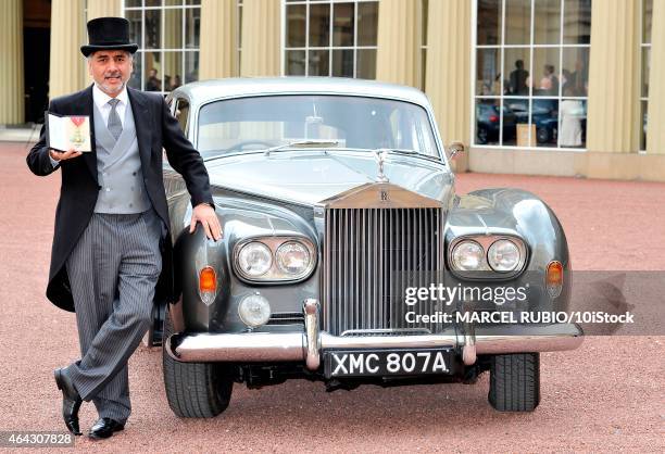 British founder and chairman James Caan stands next to his Rolls Royce car as he holds his Commander of the Order of the British Empire medal...