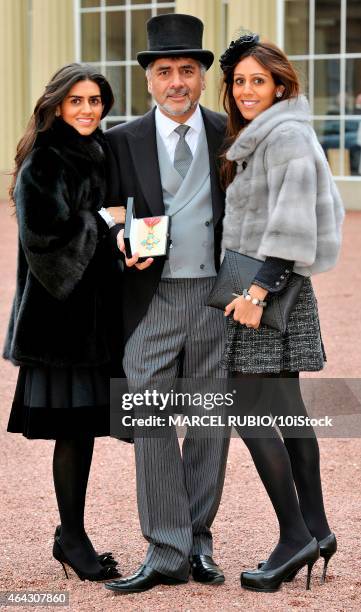 British founder and chairman James Caan poses with his daughters Hanah and Jemma Caan as he holds his Commander of the Order of the British Empire...