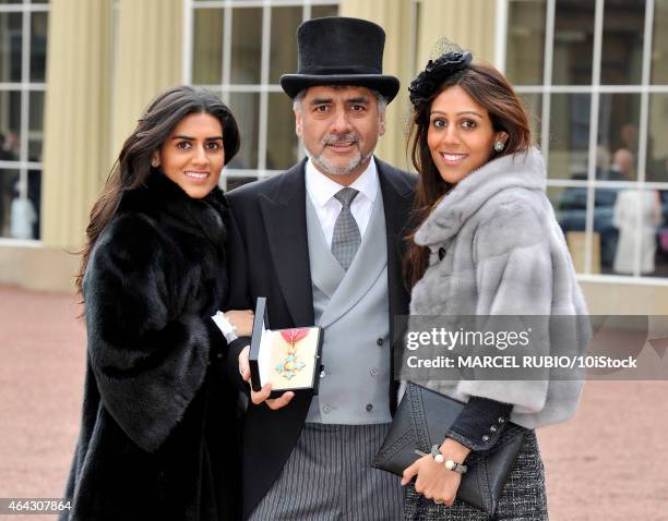 British founder and chairman James Caan poses with his daughters Hanah and Jemma Caan as he holds his Commander of the Order of the British Empire...