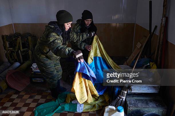 Twins, Anya and Katya, both 19 years and have been with the DPR army since October 2014, look at Ukrainian flags seized in Debaltseve in a base on...