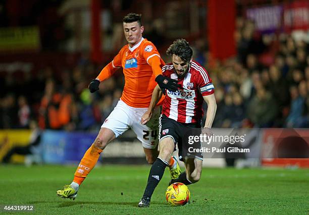 Jonathan Douglas of Brentford is pursued by Gary Madine of Blackpool during the Sky Bet Championship match between Brentford and Blackpool at Griffin...