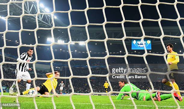 Carlos Tevez of Juventus scores their second goal past a grounded goalkeeper Roman Weidenfeller of Borussia Dortmund during the UEFA Champions League...