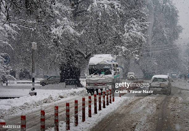 Vehicles drive on a road during snowfall on January 22, 2014 in Srinagar, Indian Administered Kashmir, India. Several parts of the Kashmir Valley,...