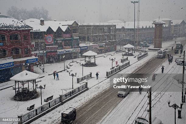 People walk at city center Lalchowk during snowfall on January 22, 2014 in Srinagar, Indian Administered Kashmir, India. Several parts of the Kashmir...