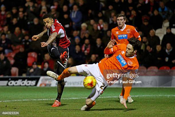 Andre Gray of Brentford scores his team's third goal despite the diving challenge from Connor Oliver of Blackpool during the Sky Bet Championship...