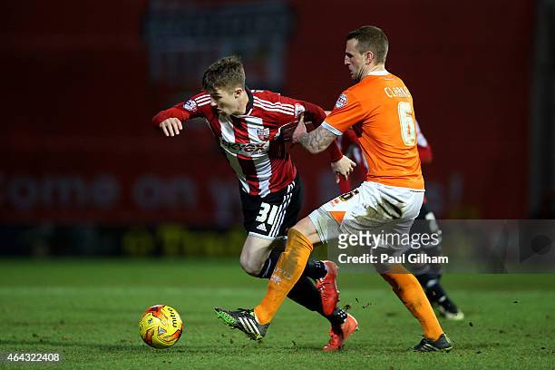 Chris Long of Brentford is held back by Peter Clarke of Blackpool during the Sky Bet Championship match between Brentford and Blackpool at Griffin...