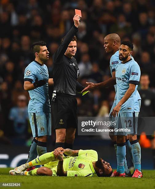 Referee Dr. Felix Brych shows Gael Clichy of Manchester City a red card during the UEFA Champions League Round of 16 match between Manchester City...