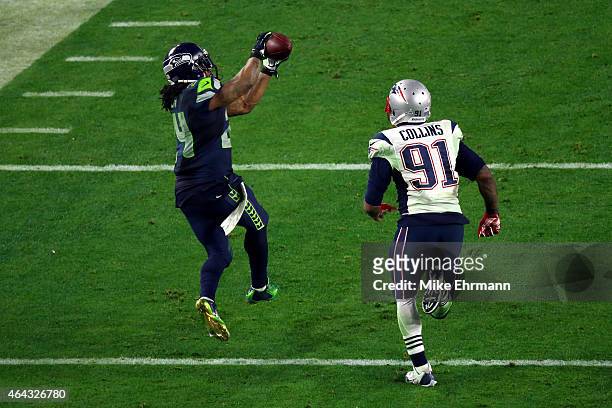 Marshawn Lynch of the Seattle Seahawks completes a catch against Tyler Gaffney of the New England Patriots in the fourth quarter during Super Bowl...