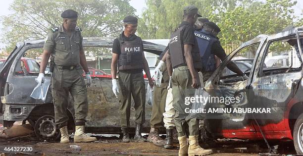 Police bomb experts sweep the scene of a twin suicide blast at Kano Line bus station in northern Nigeria's largest city of Kano on February 24, 2015....