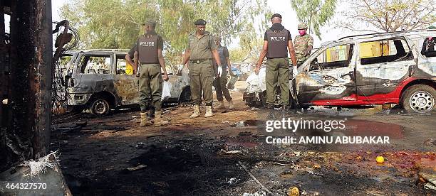 Police bomb experts inspect the scene of a twin suicide blast at Kano Line bus station in northern Nigeria's largest city of Kano on February 24,...