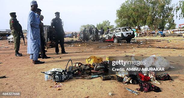 Police officers stand next to personal effects abandoned at the scene of a twin suicide blast at Kano Line bus station in northern Nigeria's largest...