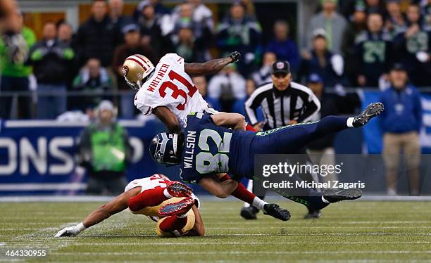 Donte Whitner of the San Francisco 49ers puts a big hit on Luke Wilson of the Seattle Seahawks during the game at CenturyLink Field on January 19,...