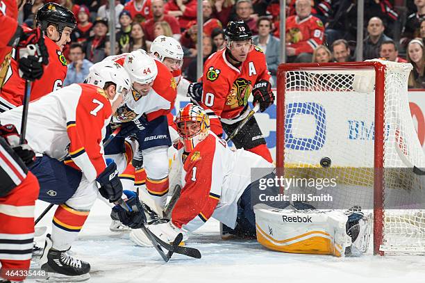 Erik Gudbranson of the Florida Panthers and Patrick Sharp of the Chicago Blackhawks watch the puck get past goalie Roberto Luongo to give the...