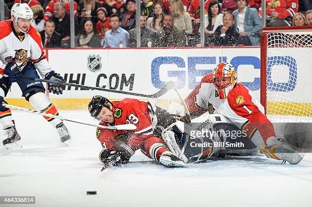 Kris Versteeg of the Chicago Blackhawks collides into goalie Roberto Luongo of the Florida Panthers as Aleksander Barkov skates in from the side...