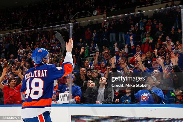 Kael Mouillierat of the New York Islanders tosses a puck to the fans after being named the second star of the game in which he scored his first...