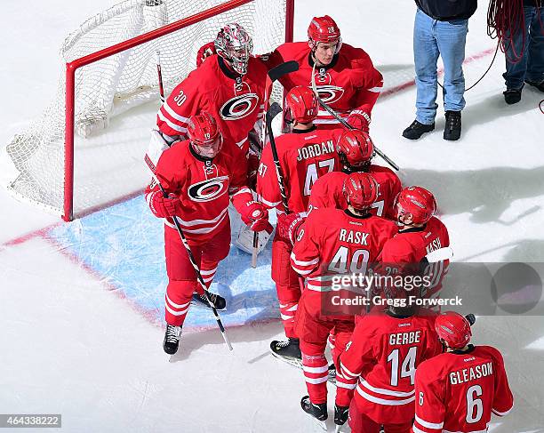 Members of the Carolina Hurricanes skate to congratulate Cam Ward after the team's 4-1 victory over the Philadelphia Flyers following an NHL game on...