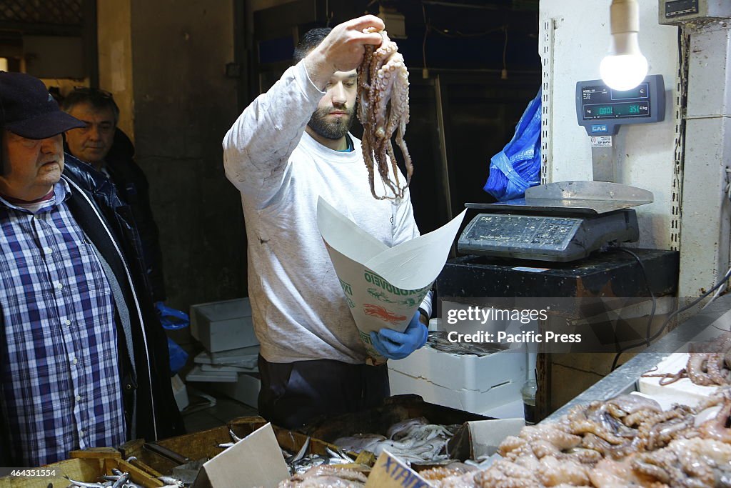 A fishmonger bags an octopus. Clean Monday is the beginning...