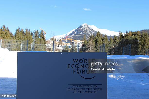The logo of the Forum is seen through with the alps in the background during the World Economic Forum in Davos, Switzerland, on January 22, 2014. The...