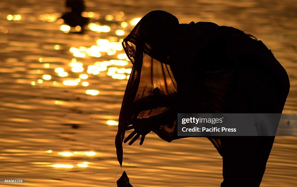 A devotee offers ritual after taking holydip during sunset...