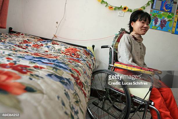 May 07: Li Yan sits in her wheel-chair in her home on May 7, 2007 in Yinchuan, Ningxia Province, China. 28-year-old Li Yan suffers from motor neuron...