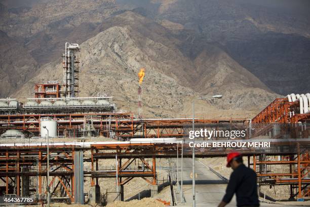 An Iranian man walks along of the phase 15-16 of the South Pars gas field facilities in the southern Iranian port of Assaluyeh on the shore of the...