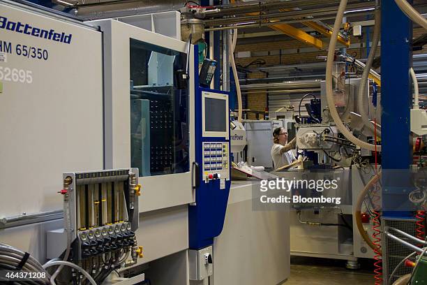 An employee operates a moulding machine in the manufacturing plant at the headquarters of Lego A/S in Billund, Denmark, on Wednesday, Feb. 25, 2015....