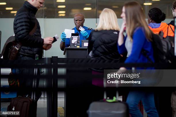 Transportation Security Administration officer checks a passenger's identification and boarding pass at a security checkpoint at Ronald Reagan...