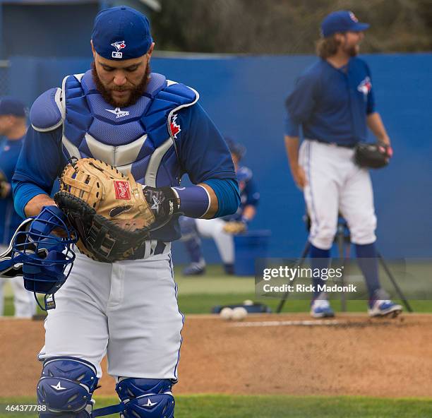 Catcher Russell Martin heads to his position behind the plate, carrying his two catchers mitts, as he prepares for his first time catching...