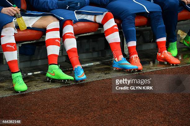 Arsenal players sit on the sustitutes bench before kick off of the UEFA Champions League round of 16 first leg football match between Arsenal and...