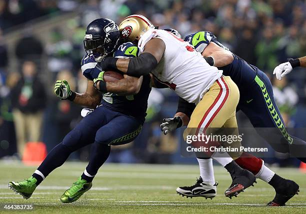 Running back Marshawn Lynch of the Seattle Seahawks carries the ball as defensive end Ray McDonald of the San Francisco 49ers defends during the 2014...