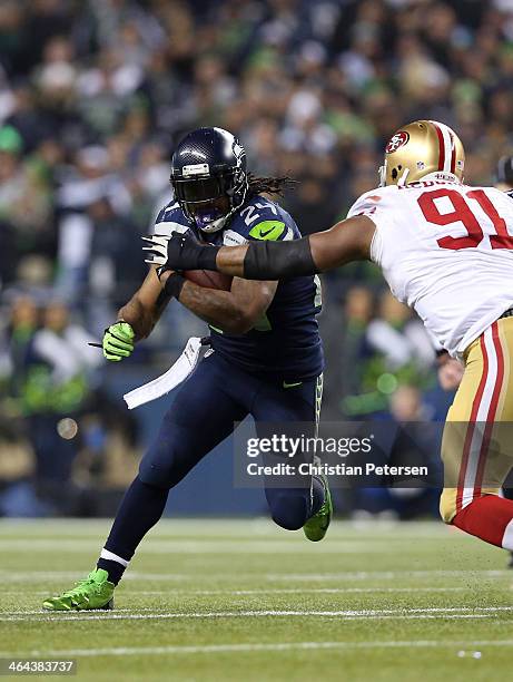 Running back Marshawn Lynch of the Seattle Seahawks carries the ball as defensive end Ray McDonald of the San Francisco 49ers defends during the 2014...