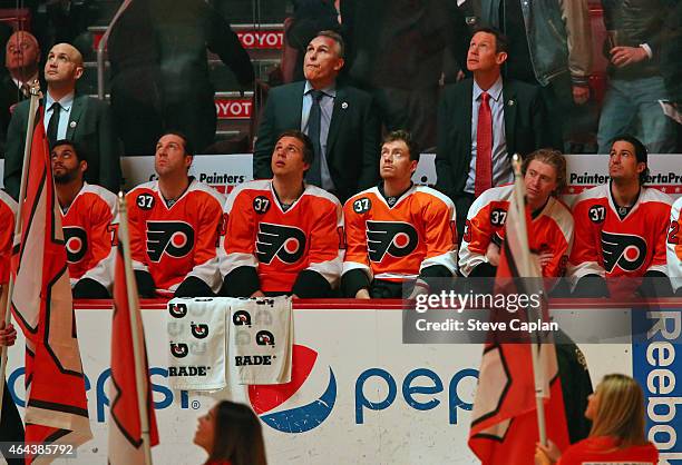 Members of the Philadelphia Flyers watch a video Honoring Eric Desjardins on his Flyer Hall of Fame Induction Ceremony prior to a game against the...