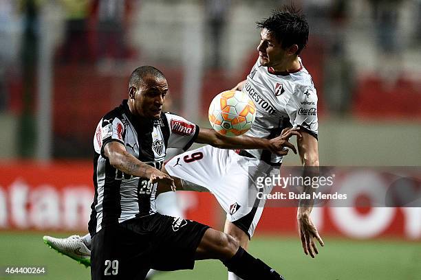Patric of Atletico MG struggles for the ball with a Luis Caballero of Atlas during a match between Atletico MG and Atlas as part of Copa Bridgestone...