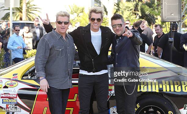 Singer Gary LeVox, guitarist Joe Don Rooney and bassist Jay DeMarcus of the band Rascal Flatts pose after arriving by NASCAR race cars at the Hard...
