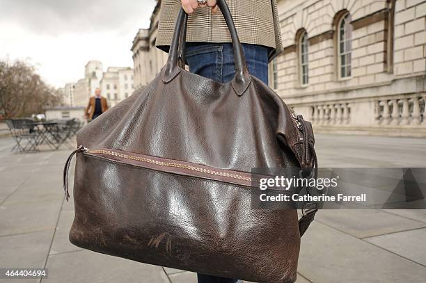 Shunichiro Naka, fashion design student from Tokyo accessorizing his vintage look with a hand made bag by Turnover during London Fashion Week...