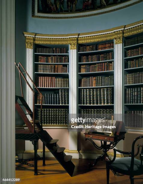 The library, Kenwood House, Hampstead, London, 1989. Leather-bound volumes within shelves decorated with gilt and classical columns. A set of wooden...