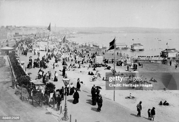 The seafront at Weymouth, Dorset, 1890s. The crowded beach and promenade at the popular resort of Weymout in Dorset. In the centre is a hut marked...