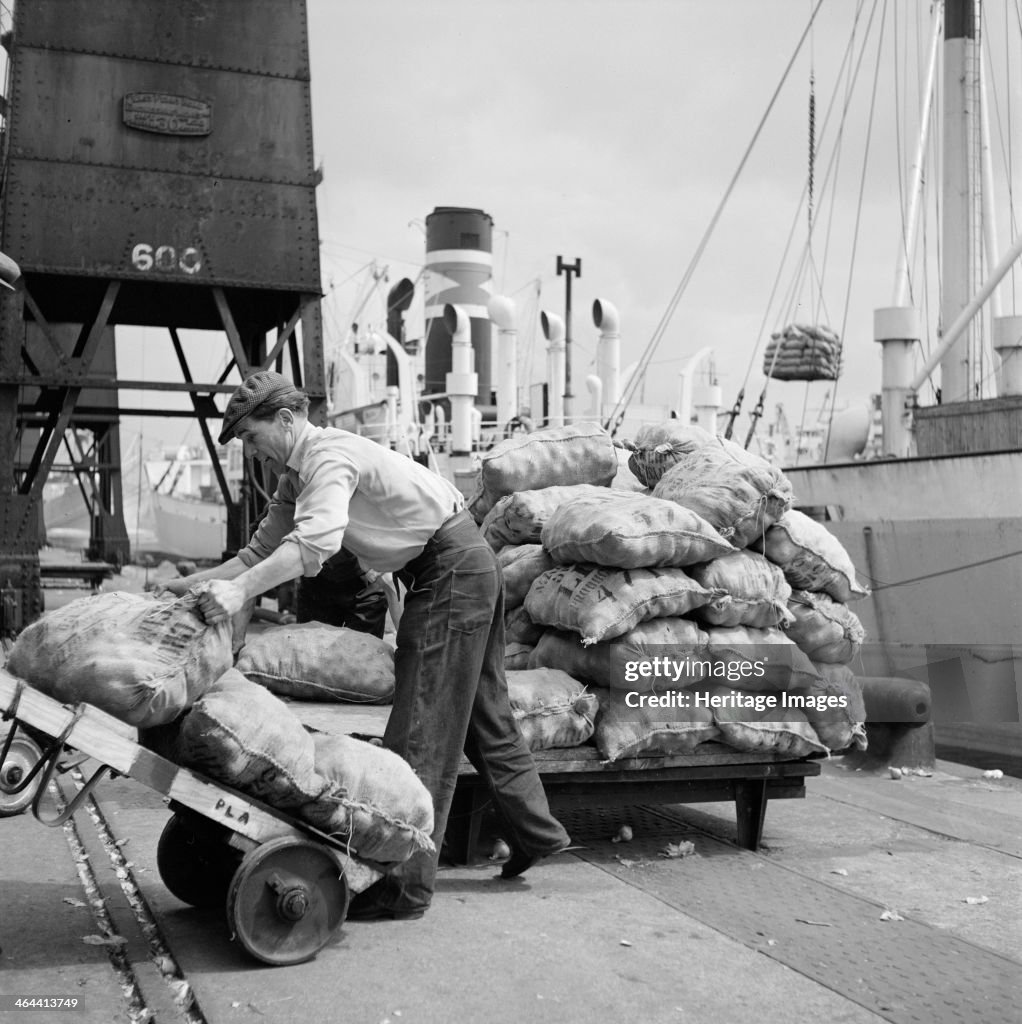 Sacks of vegetables being loaded onto a ship in London docks, c1945-c1965. Artist: SW Rawlings