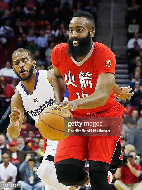 James Harden of the Houston Rockets drives with the basketball past Chris Paul of the Los Angeles Clippers during their game at the Toyota Center on...
