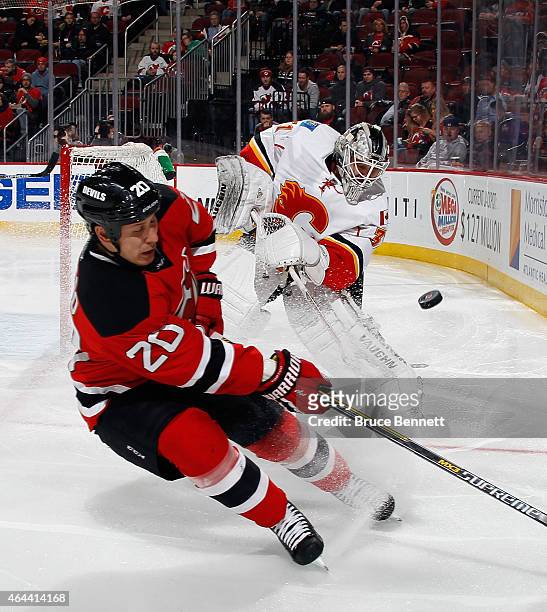 Karri Ramo of the Calgary Flames shoots the puck away from the onrushing Jordin Tootoo of the New Jersey Devils during the second period at the...