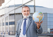 Mature man holding a globe