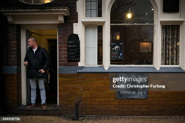 Man smokes a cigarette outside a pub in Bilston, West Midlands on February 11, 2015 in Bilston, United Kingdom. As the United Kingdom prepares to...