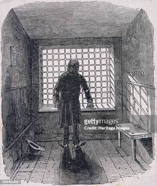Interior view of poor debtors' room in Fleet Prison, London, c1820; back view of a man looking out through bars.