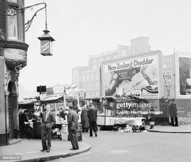 Tubby Isaacs stall, Middlesex Street, Aldgate, London, . One of a line of a line of stalls in a street market. A policeman stand on the street...