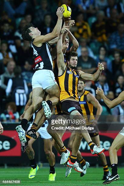 Corey Gault of the Magpies marks the ball over Ben Stratton of the Hawks during the NAB Challenge AFL match between Hawthorn Hawks and the...