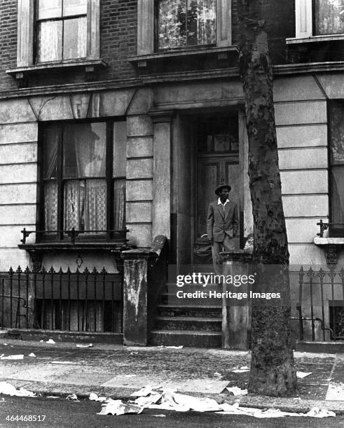 Man standing outside a house in Westbourne Grove, possibly in Kensington, London, 1950s.