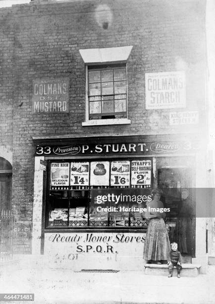 Stuart's Grocery Shop, King Henry Street, Islington, London. The shop front, with two women and a small boy in the doorway to the shop. The shop...