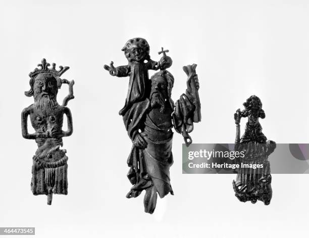 Three medieval pilgrim badges. These show saints - the one in the centre may be St Christopher, patron saint of travellers. The badges signified that...